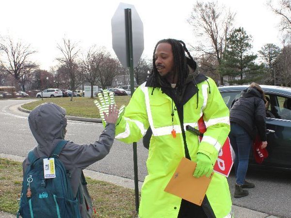 James Patterson, a RPS Crossing Guard, gives a high five to a student.